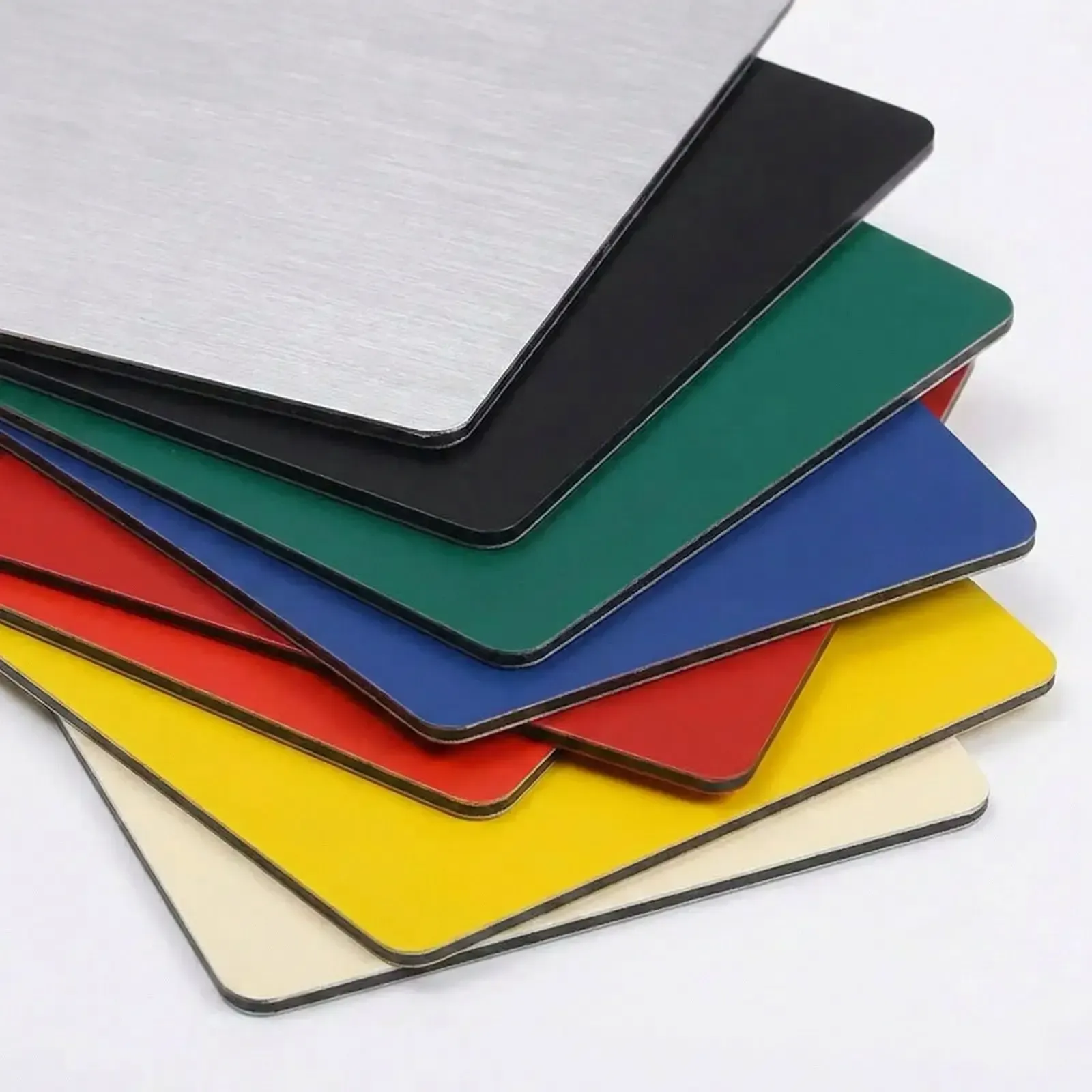 Campionario lastre DIBOND® alluminio composito: dettaglio finitura spazzolata e colori nero, verde, blu, rosso, giallo, avorio con nucleo nero a vista.