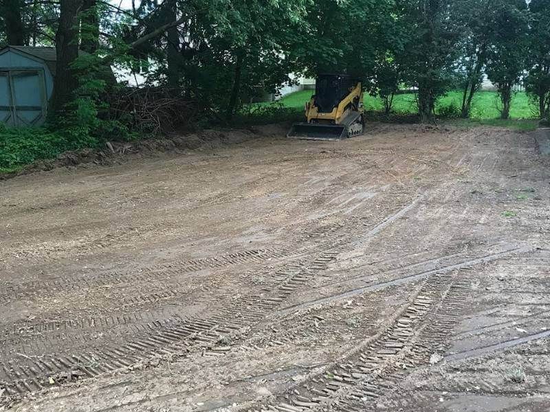 Backyard grading with trees and compact track loader in Blue Grass, IA