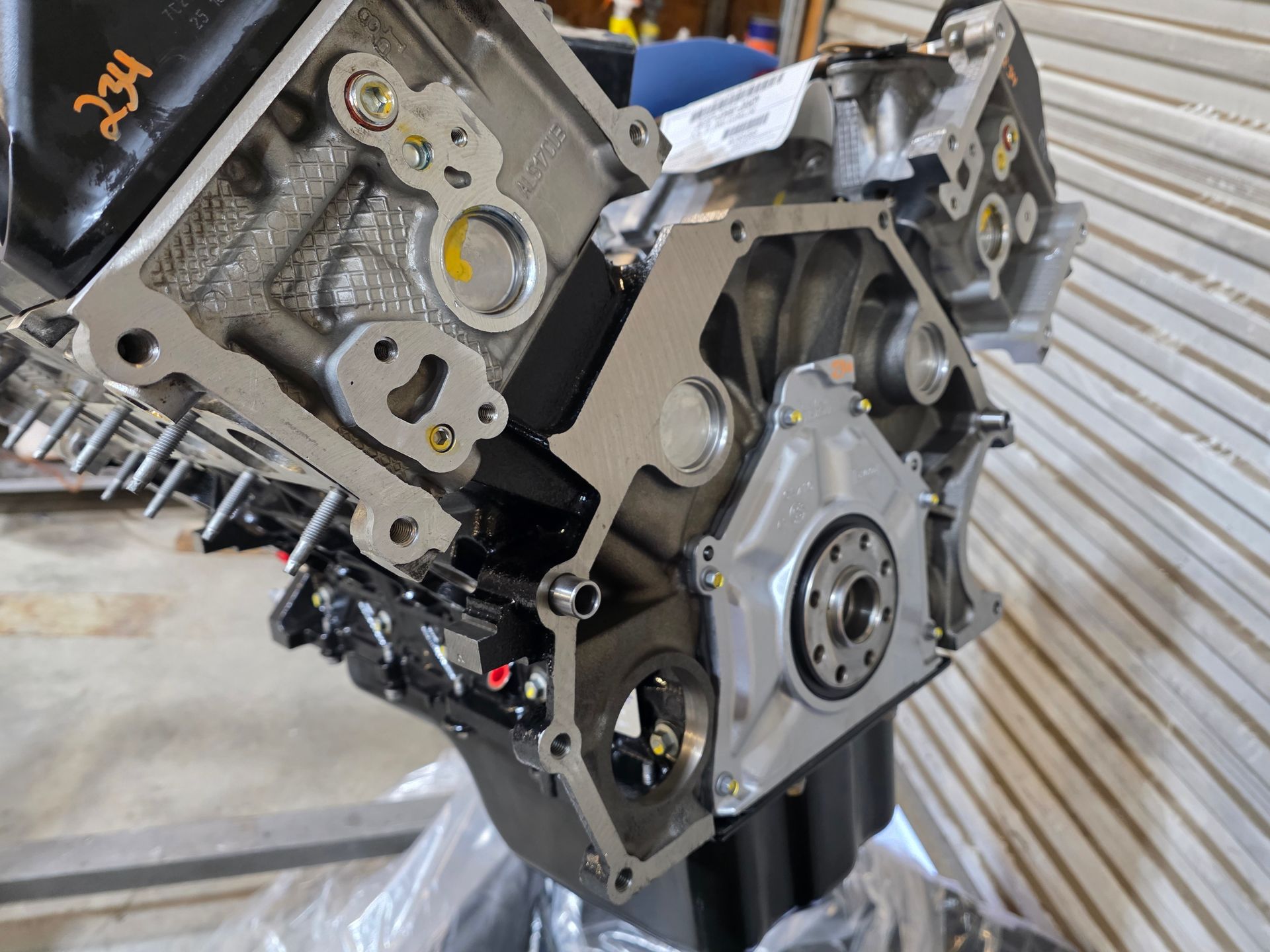 Close-up of a metallic engine block with gears and components mounted on a stand in a workshop. | Masters Auto Group