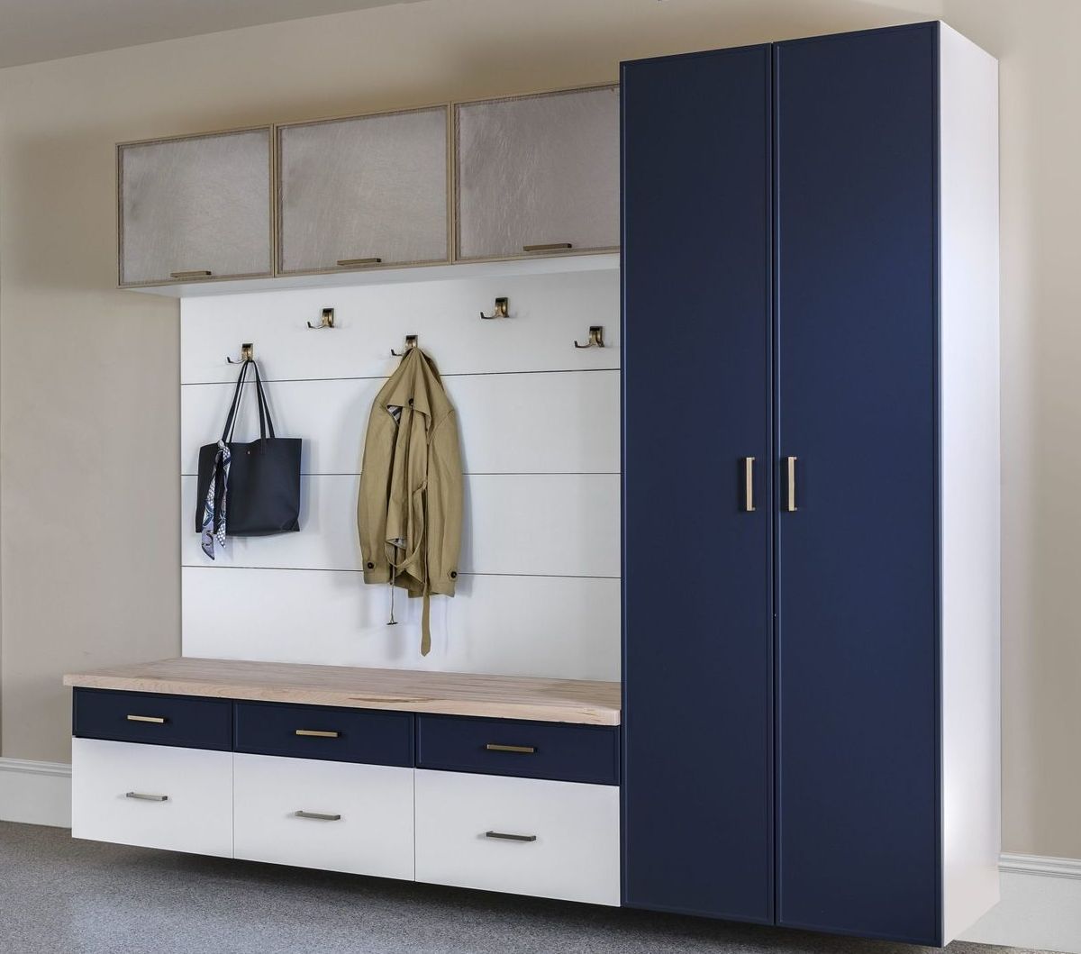 a blue and white mudroom cabinet with a coat hanging on it