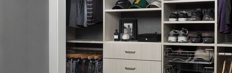 organized custom reach-in closet system filled of shoes, caps  and pants