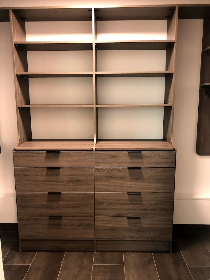 a walk in closet with lots of shelves and drawers .