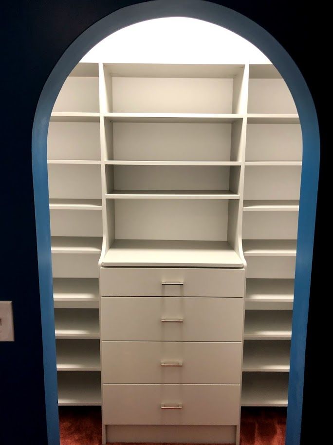 a closet with lots of shelves and drawers