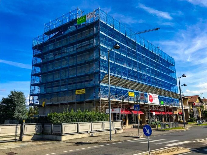Si sta costruendo un grande edificio circondato da impalcature.