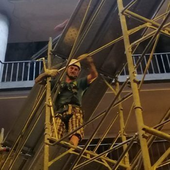 Un uomo che indossa un casco è in piedi su un'impalcatura