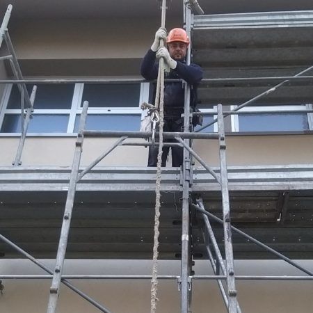 Un uomo che indossa un casco è in piedi su un'impalcatura