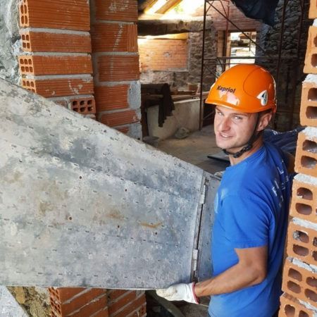 Un uomo che indossa un casco arancione con il numero 4 sopra