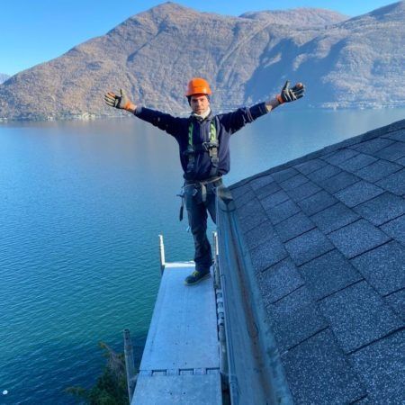 Un uomo è in piedi su un'impalcatura che domina un lago.