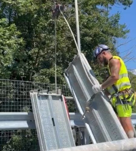 Un uomo con un gilet giallo sta lavorando su una gru.