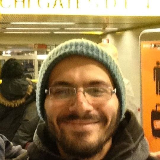 Un uomo con gli occhiali e un berretto sorride alla telecamera. Personale qualificato.