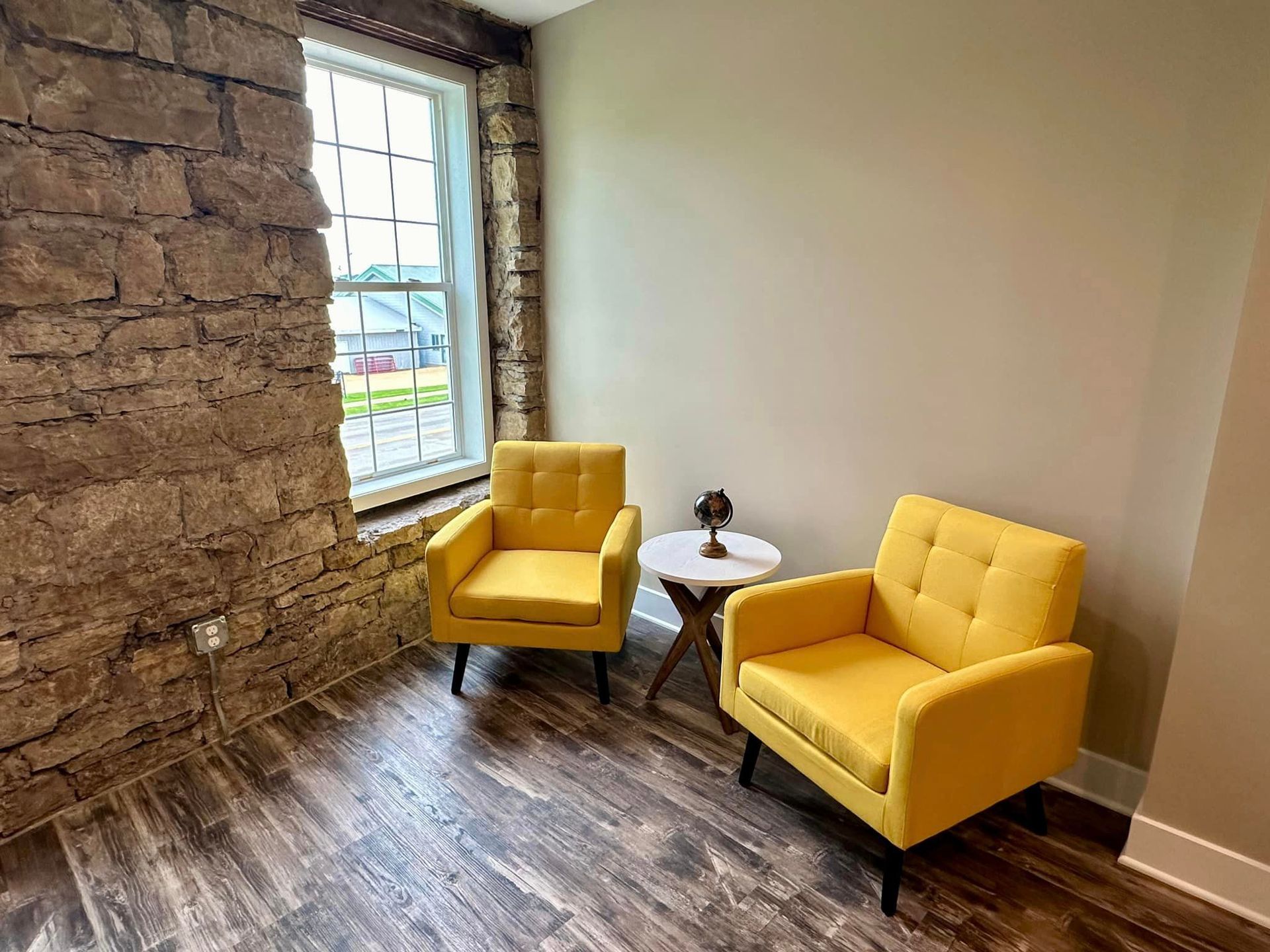 There are two yellow chairs and a table in the room.