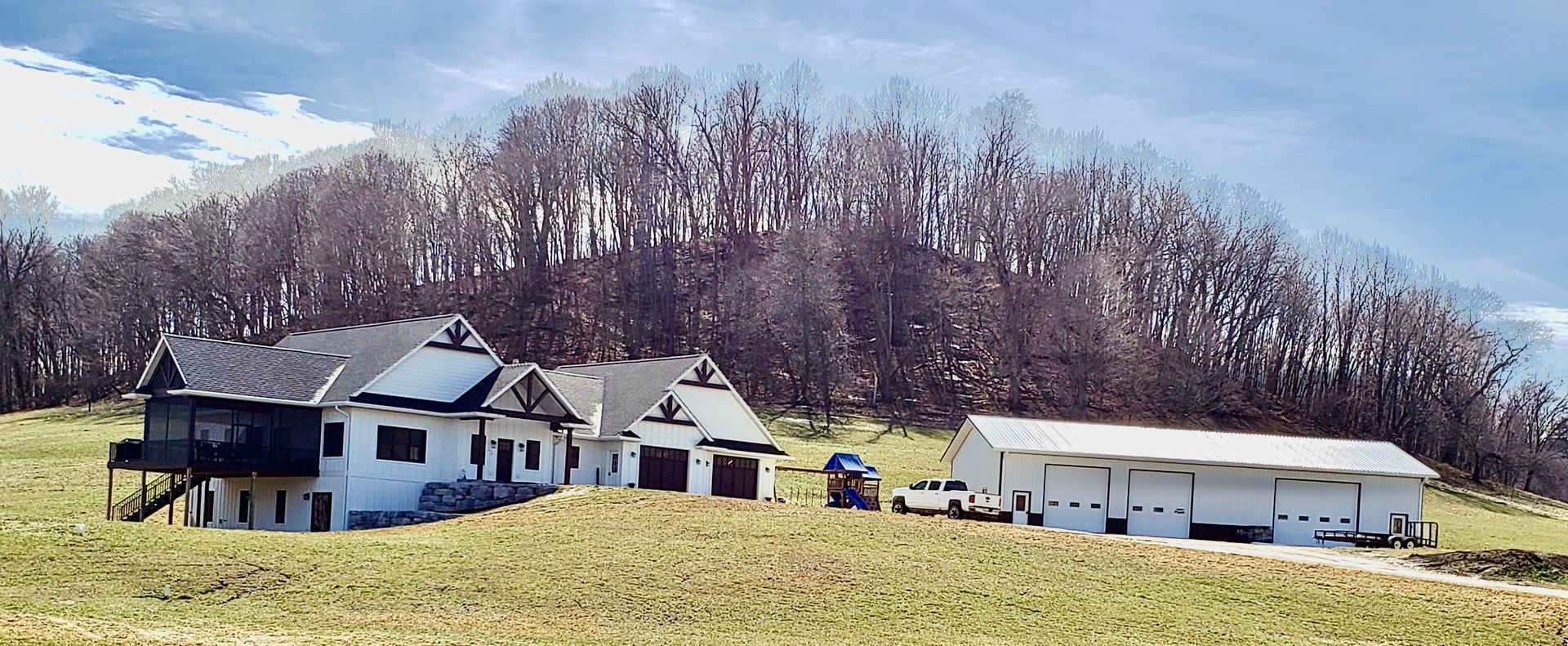 A group of houses are sitting on top of a grassy hill.