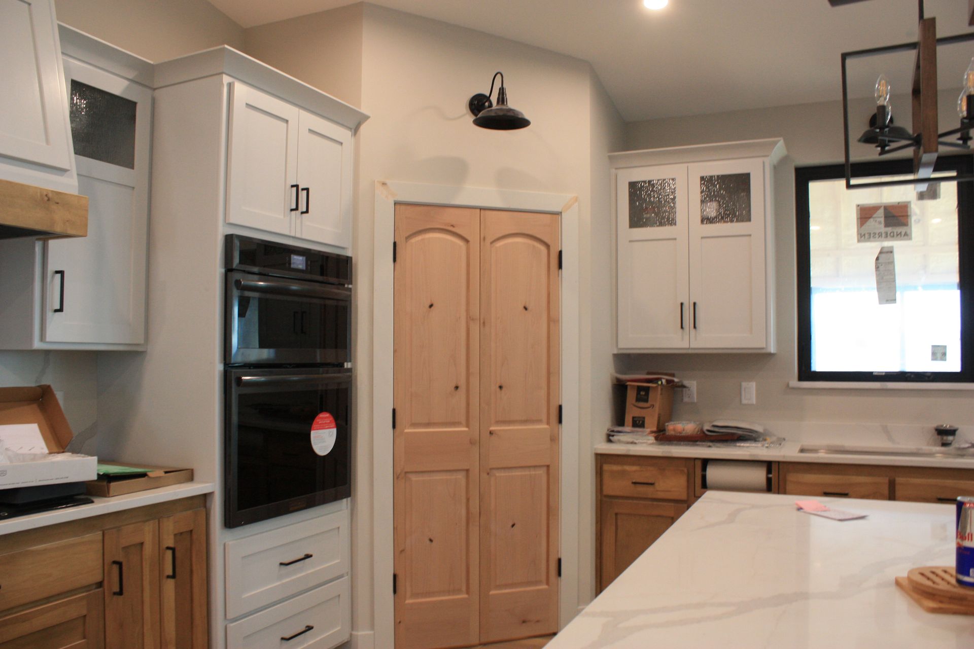 A kitchen with white cabinets , wooden cabinets , a microwave oven , and a large island.