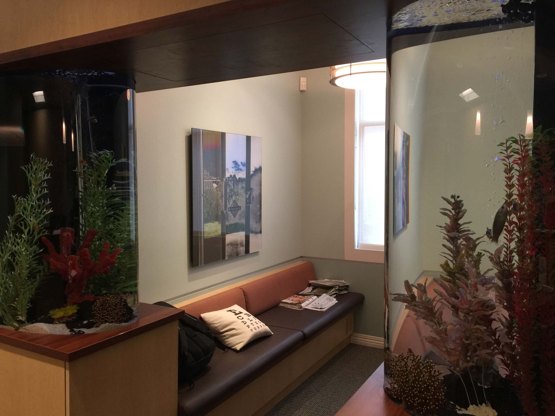 A waiting room with a couch and a fish tank