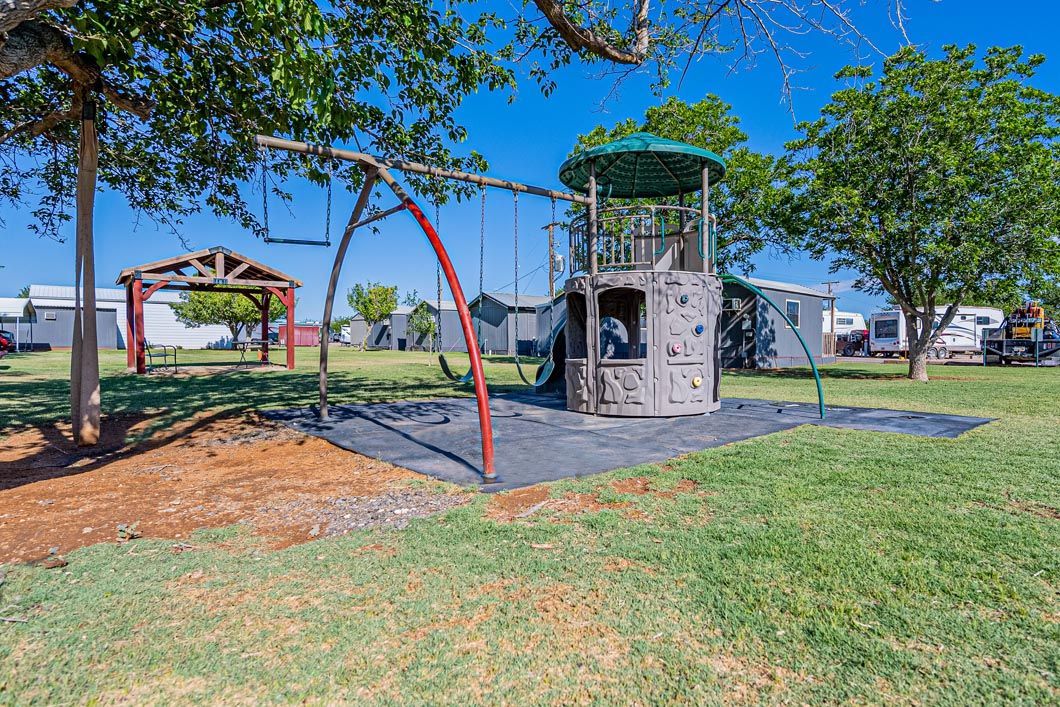 A playground with swings and a climbing wall in a park