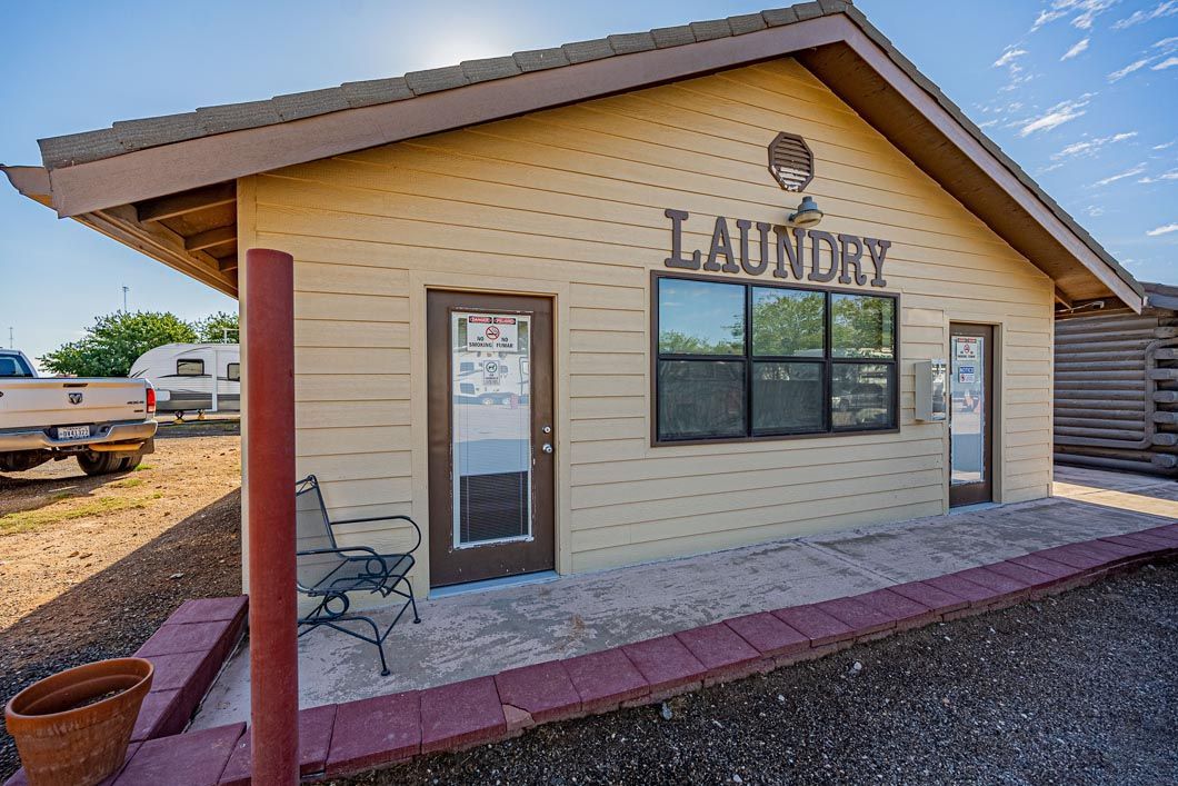 A small laundry building with a bench in front of it