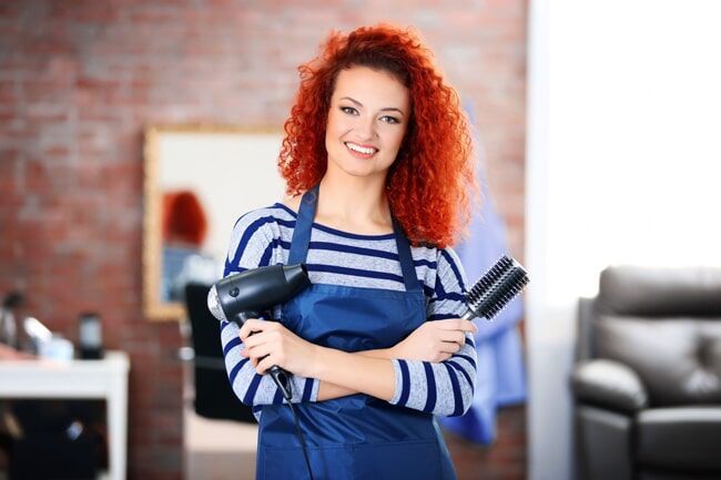 Professional Hairdresser  Holding A Blower And Hairbrush — KD's Hair Design In Soldiers Point, NSW