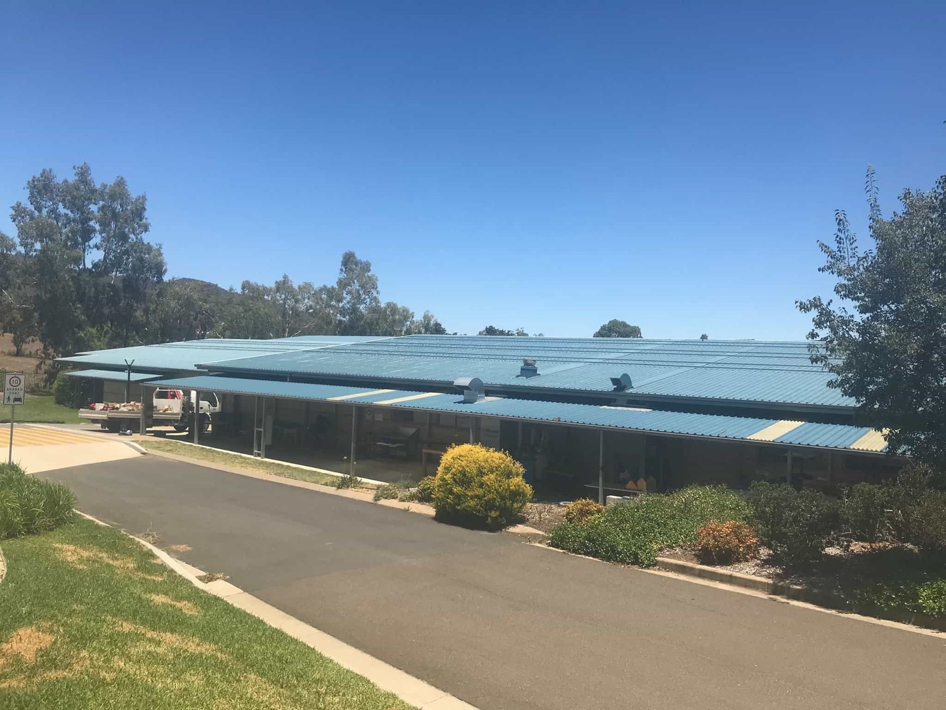 A Row Of Houses With A Blue Roof On A Sunny Day — Max Fox Electrical in Quirindi, NSW