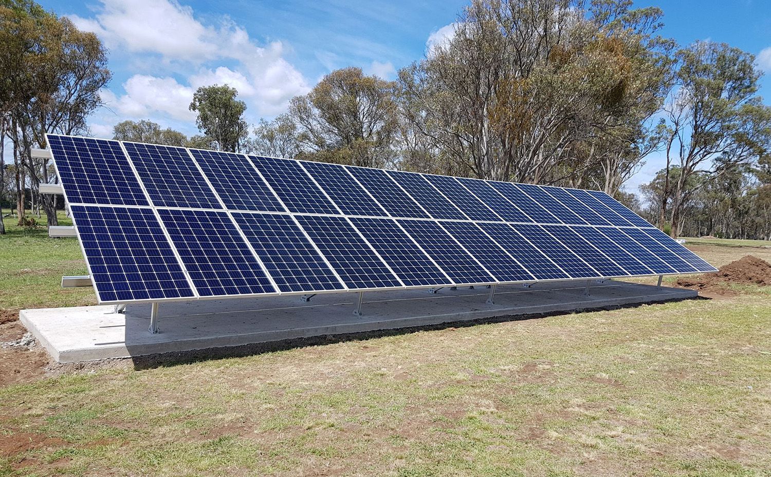Solar Panel Array Installed In A Grassy Field