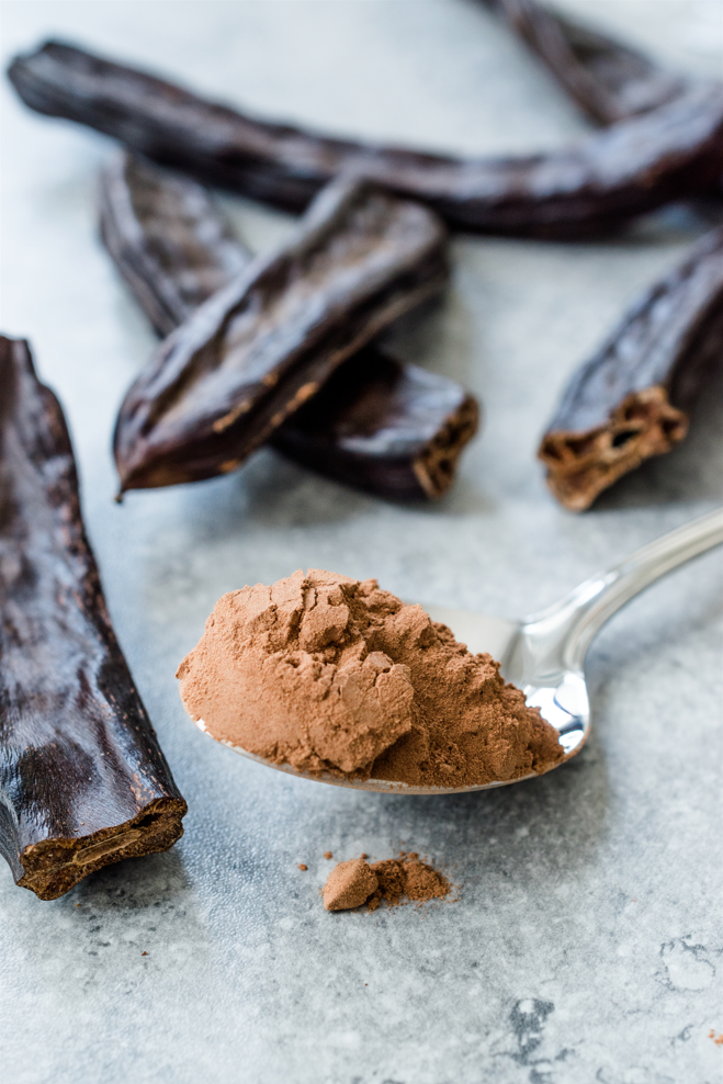 Un gros plan d'une cuillère remplie de poudre de cacao.