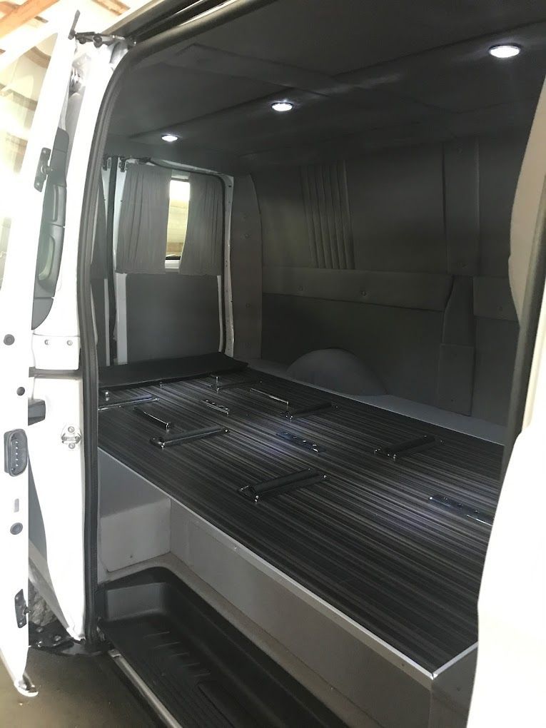 A white car is parked in a garage next to a blue car.