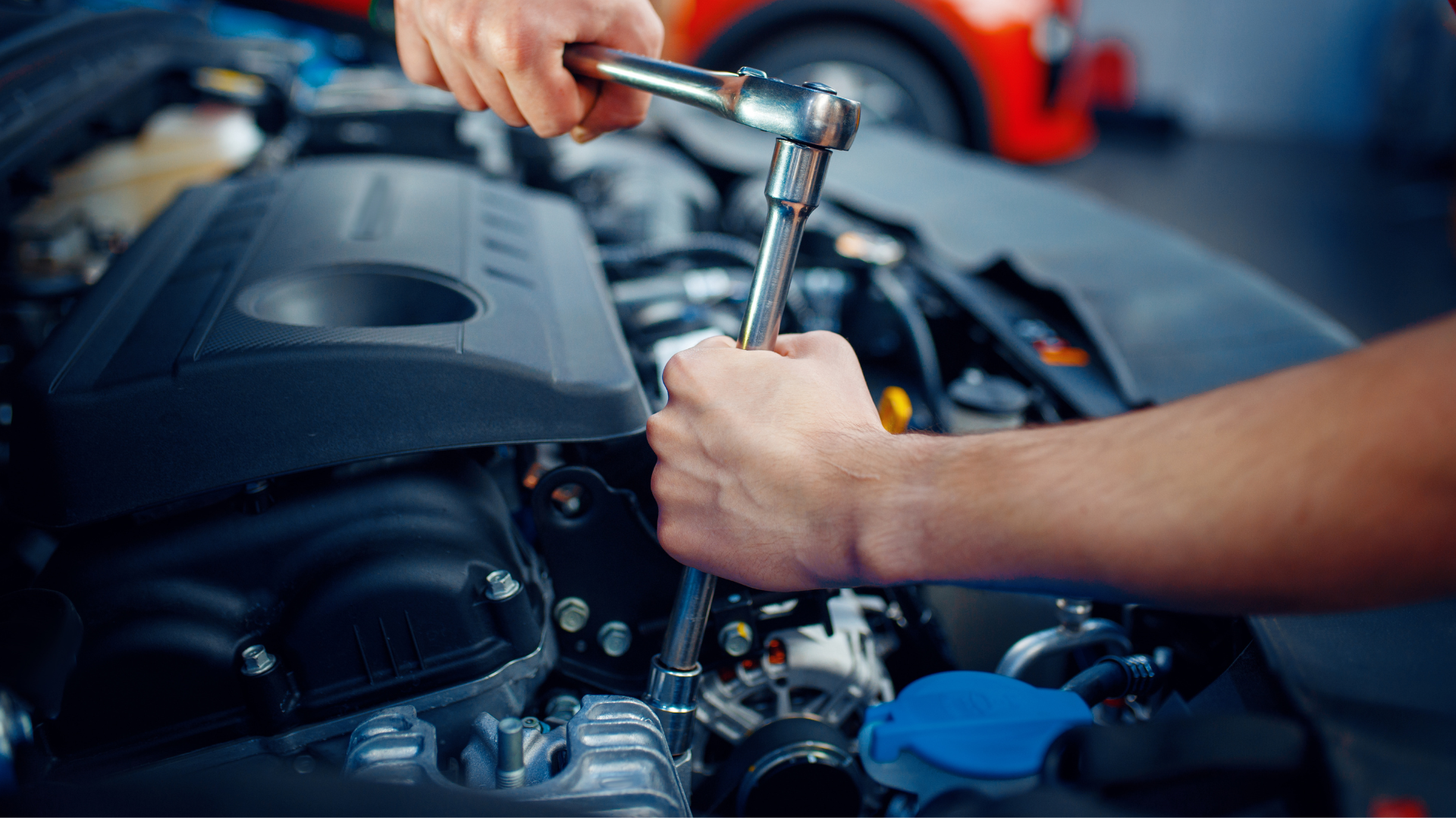 A black funeral car is parked in a gravel lot.