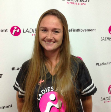 A woman wearing a ladies first shirt smiles for the camera