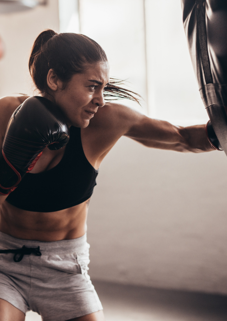 A group of people are boxing in a gym with a sign that says t on it