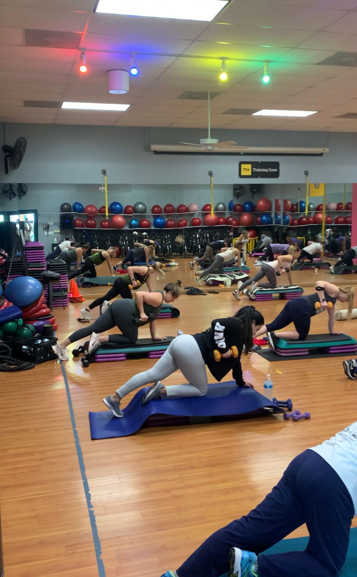 A group of people are doing exercises in a gym.