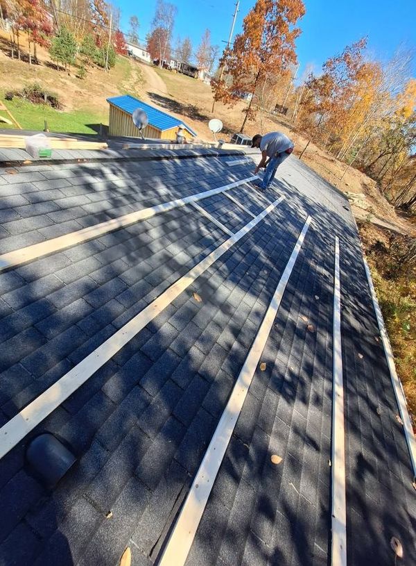 A man is working on the roof of a house.