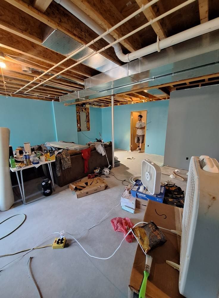 A man is standing in a basement under construction.