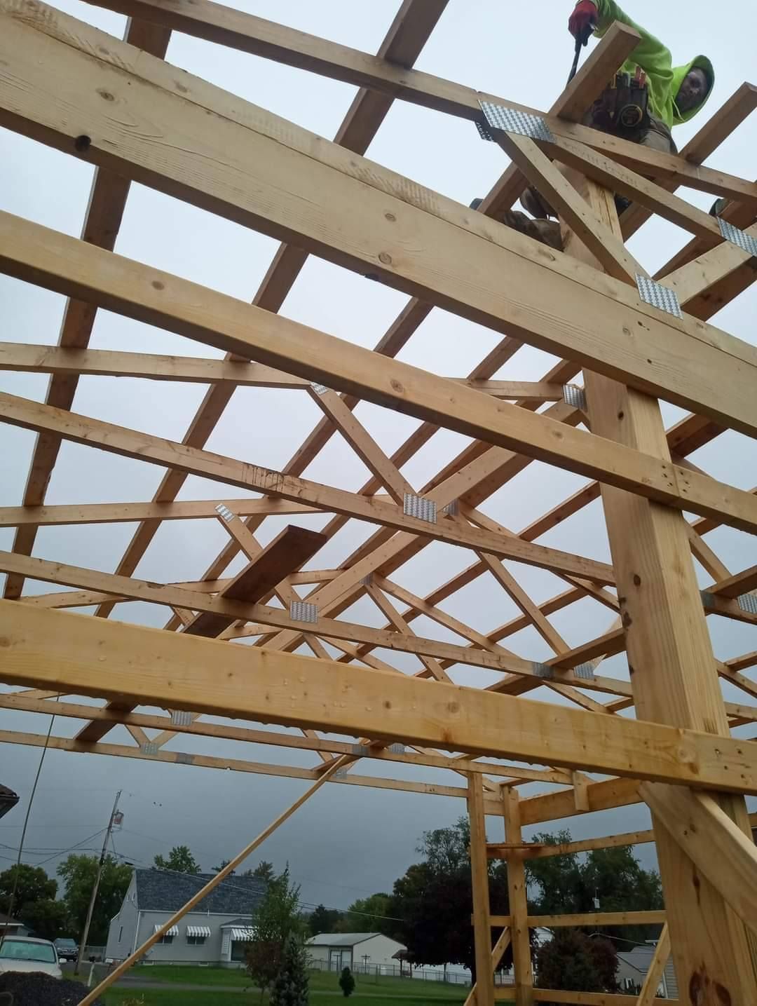 A man is working on the roof of a wooden structure.
