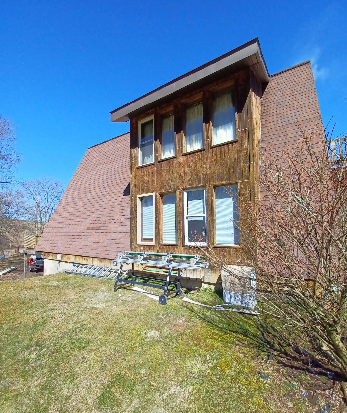 A large house with a brick roof and a lot of windows