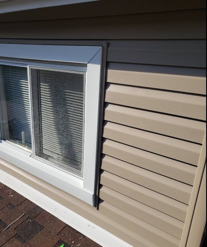 A window on the side of a house with blinds on it