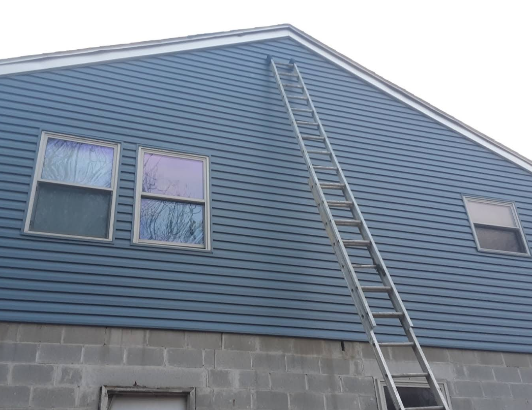 A ladder is attached to the side of a house.
