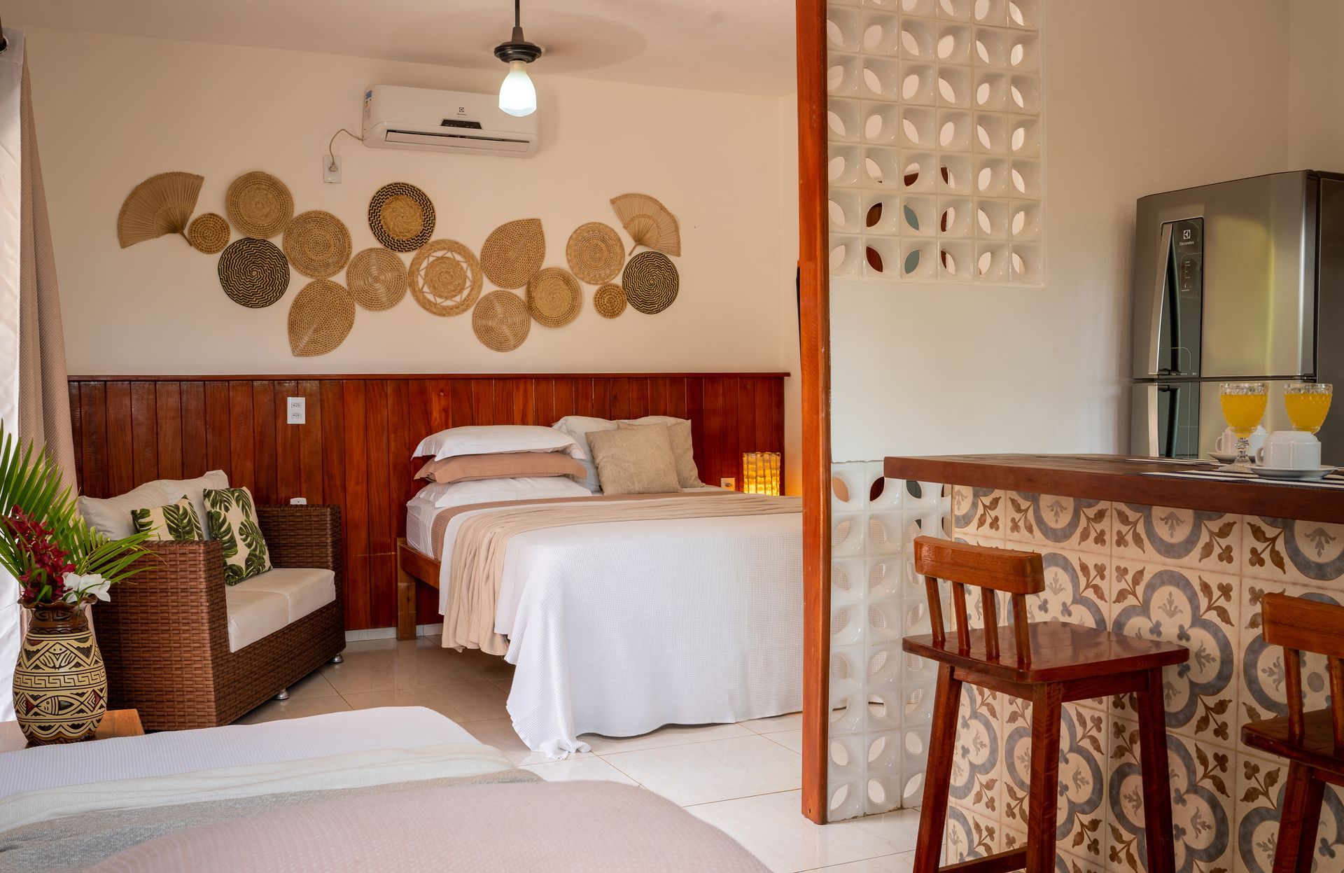 Um quarto com duas camas, um sofá e um bar.
