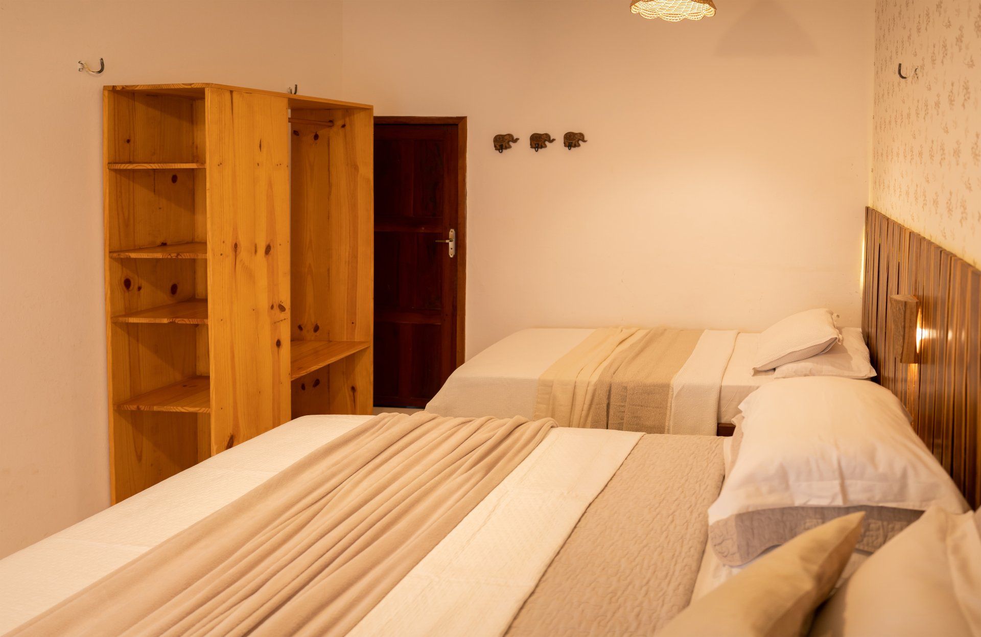 Um quarto de hotel com duas camas e um guarda-roupa.