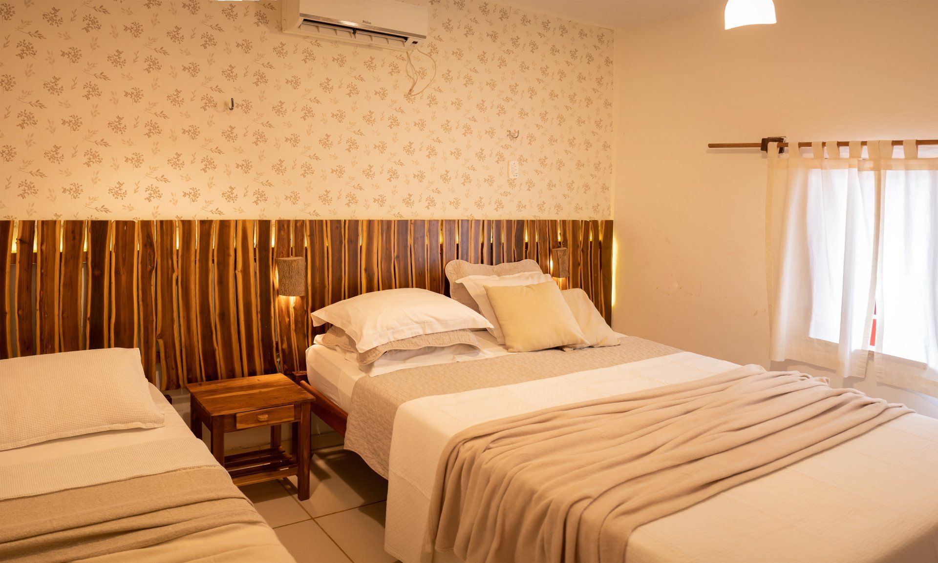 Um quarto de hotel com duas camas e uma janela.