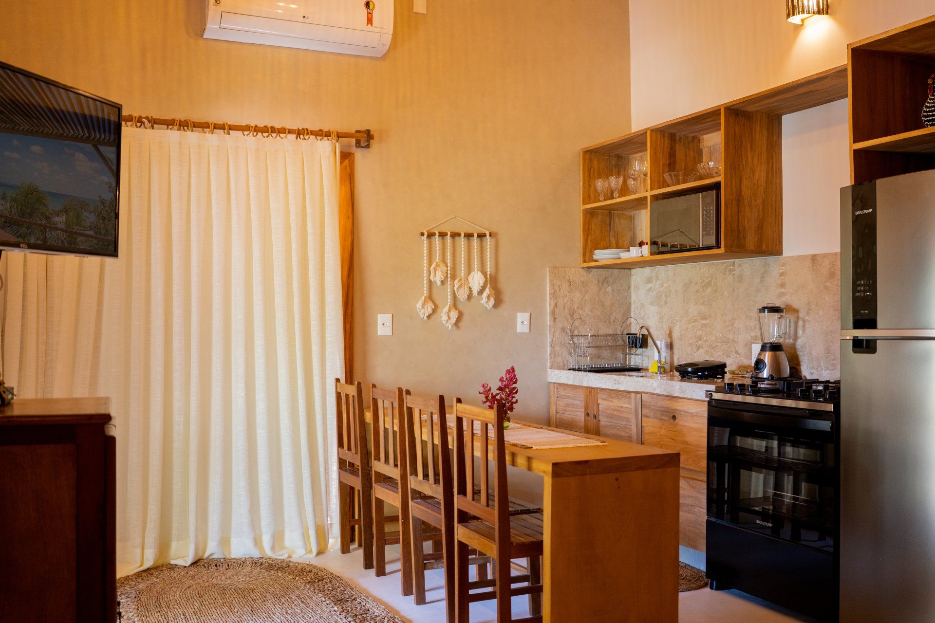 Uma cozinha com mesa, cadeiras e geladeira