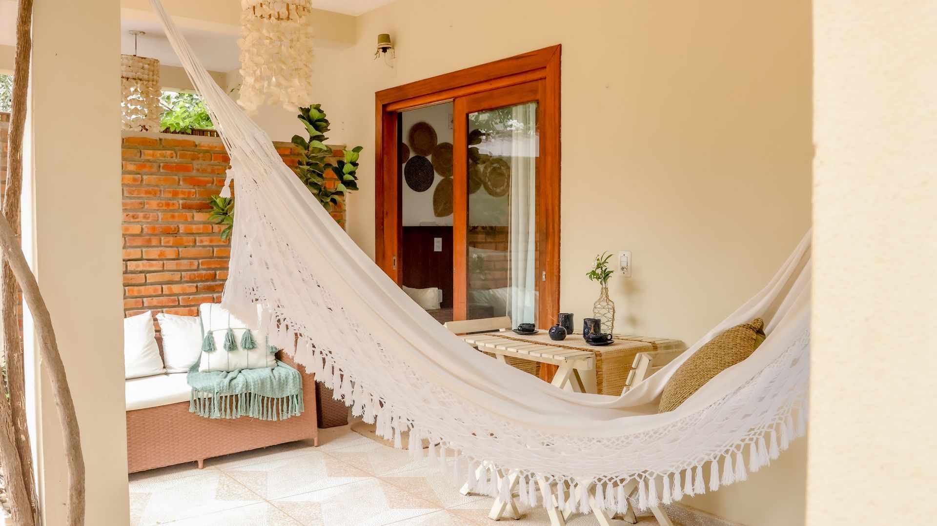 Uma rede branca está pendurada na varanda de uma sala de estar