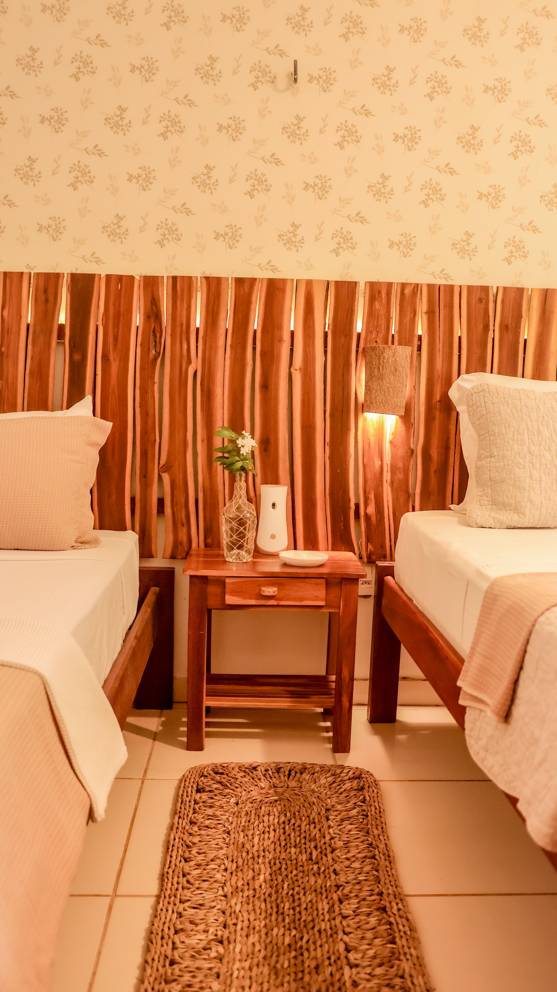 Um quarto com duas camas e uma cabeceira de madeira