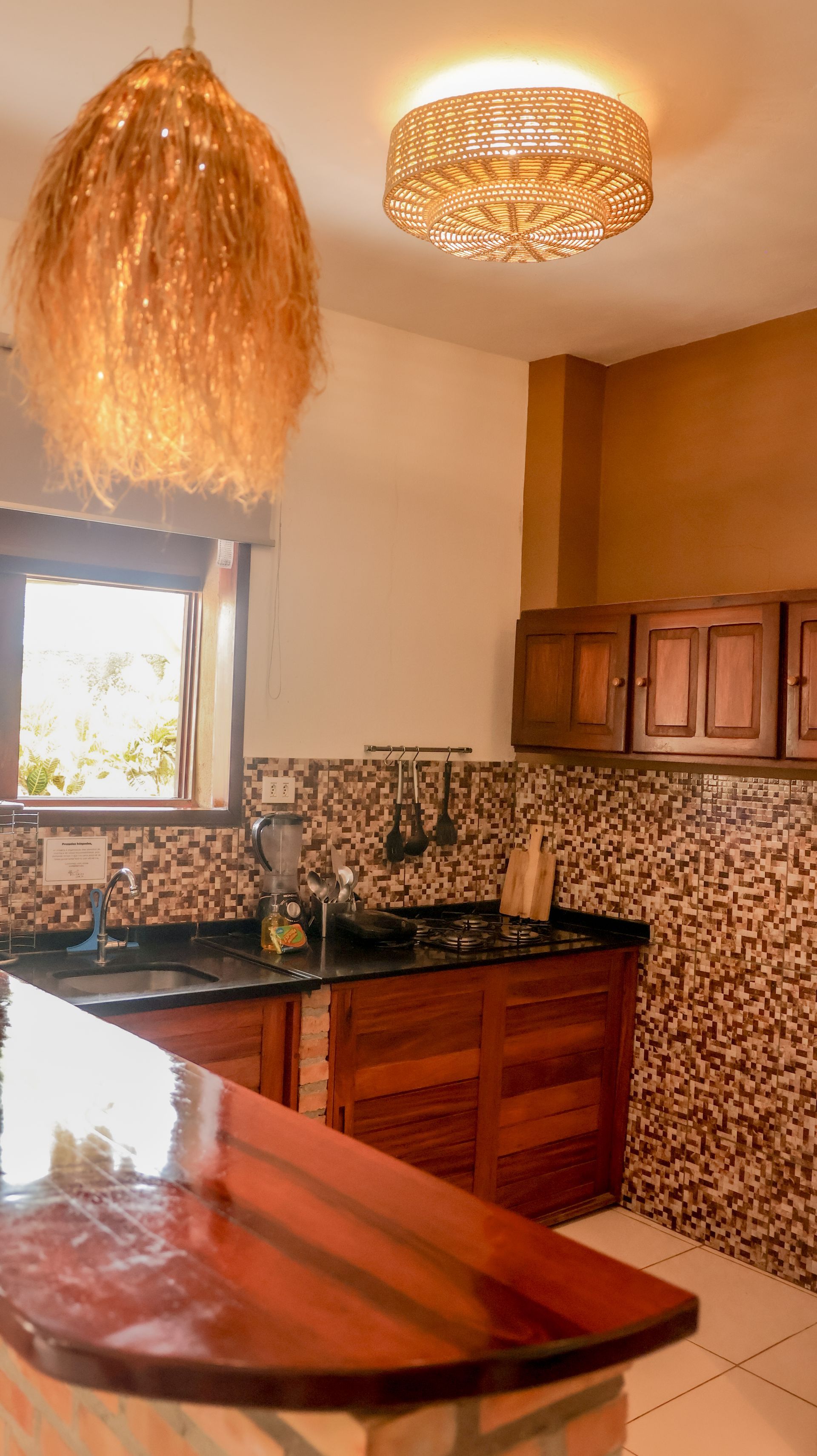 Uma cozinha com armários de madeira e uma luminária de teto