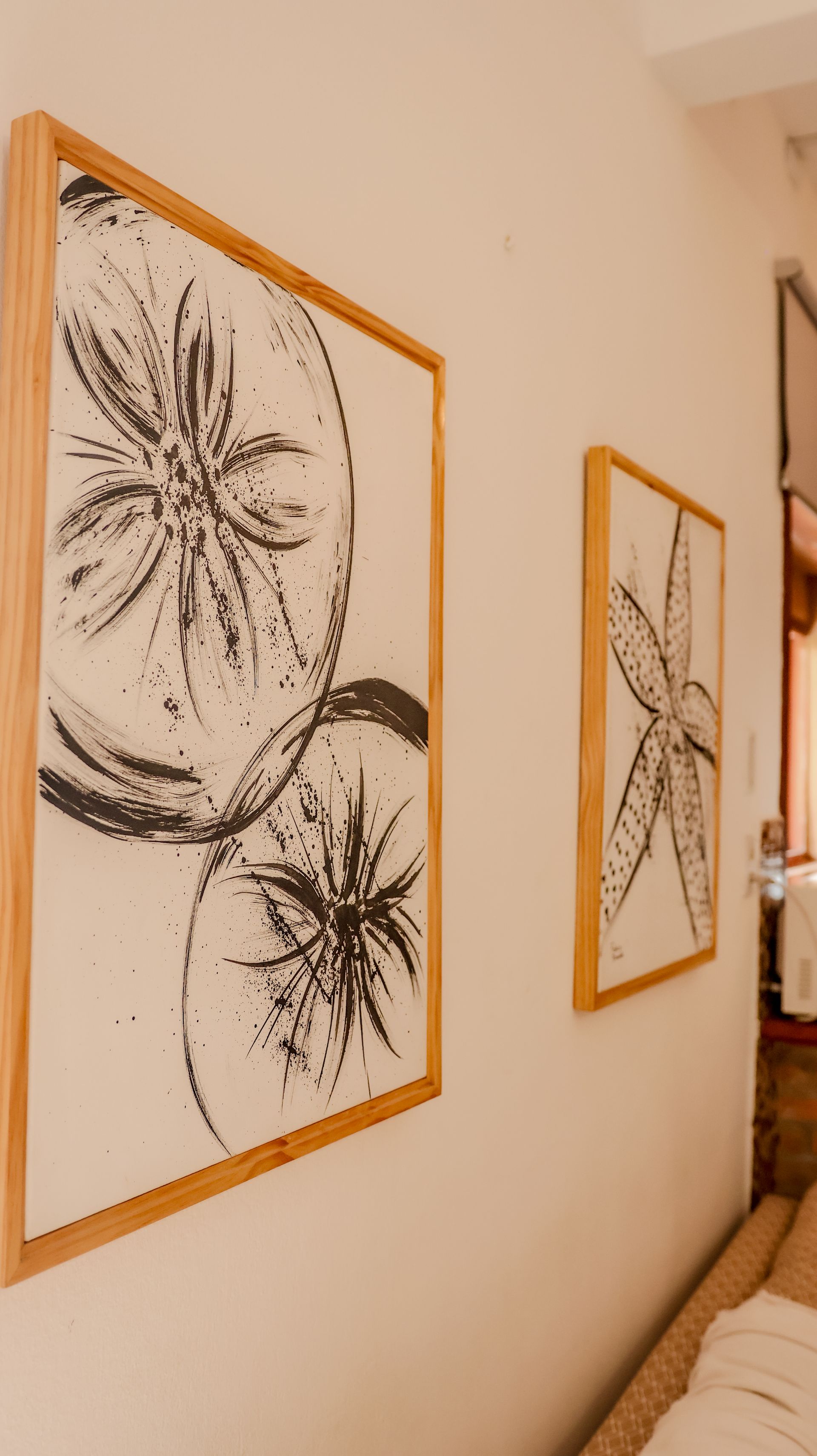 Duas fotos emolduradas em uma parede com um sofá ao fundo