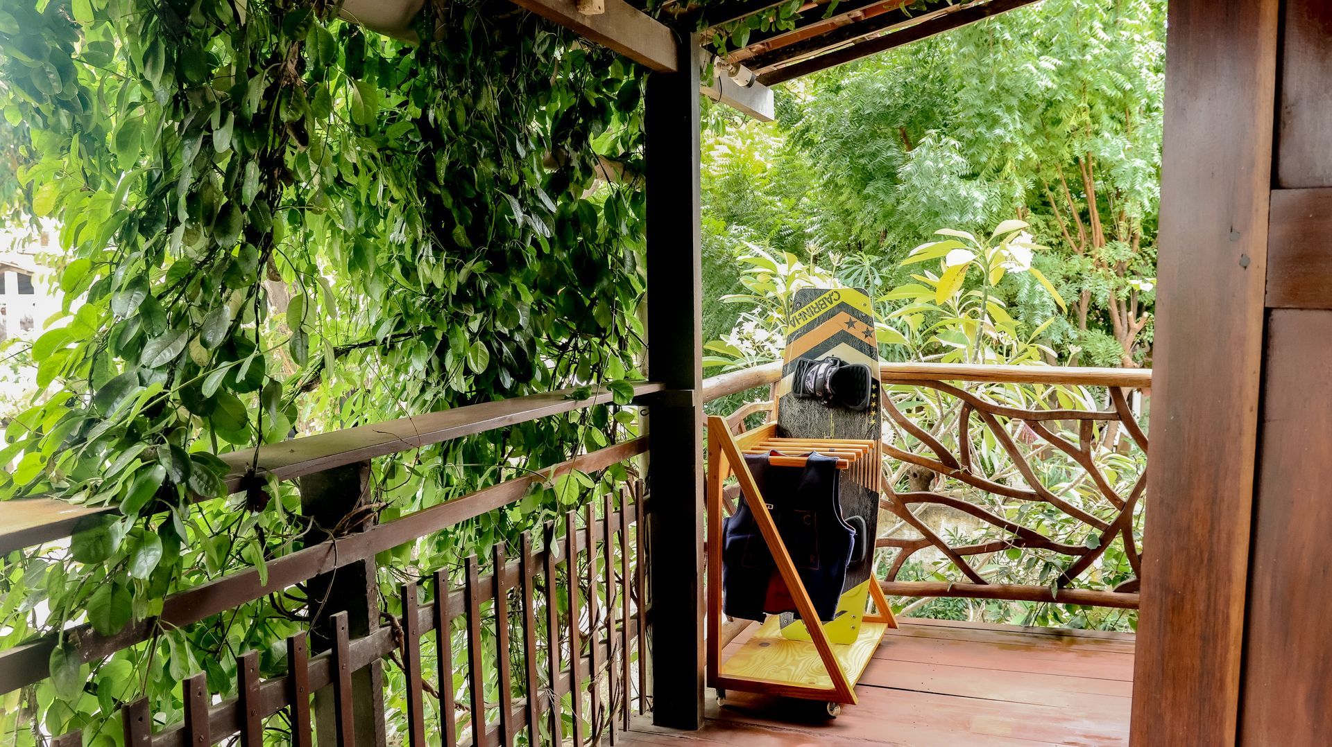 Uma varanda com corrimão de madeira cercada por árvores