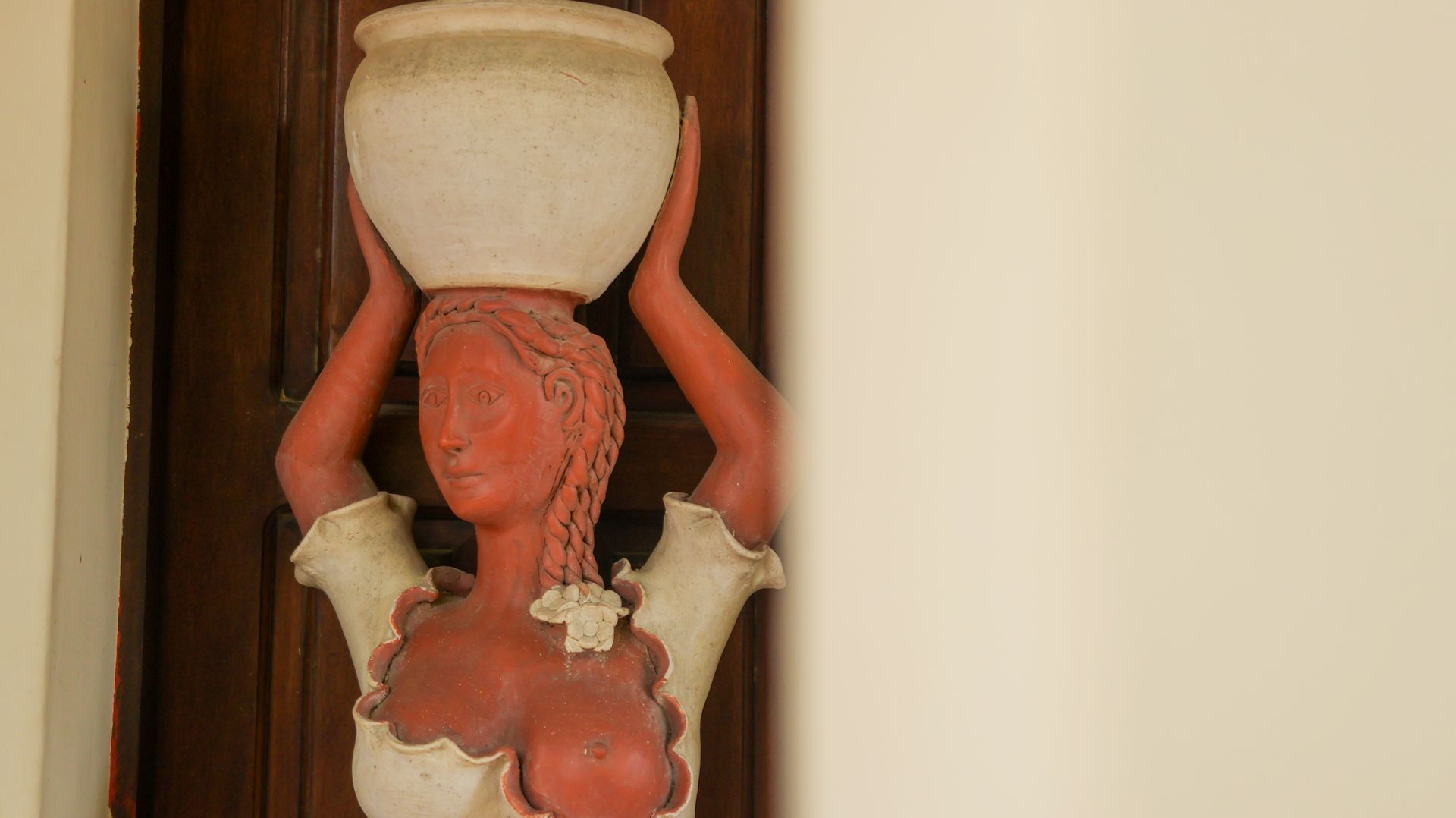 Uma estátua de uma mulher segurando uma tigela na cabeça