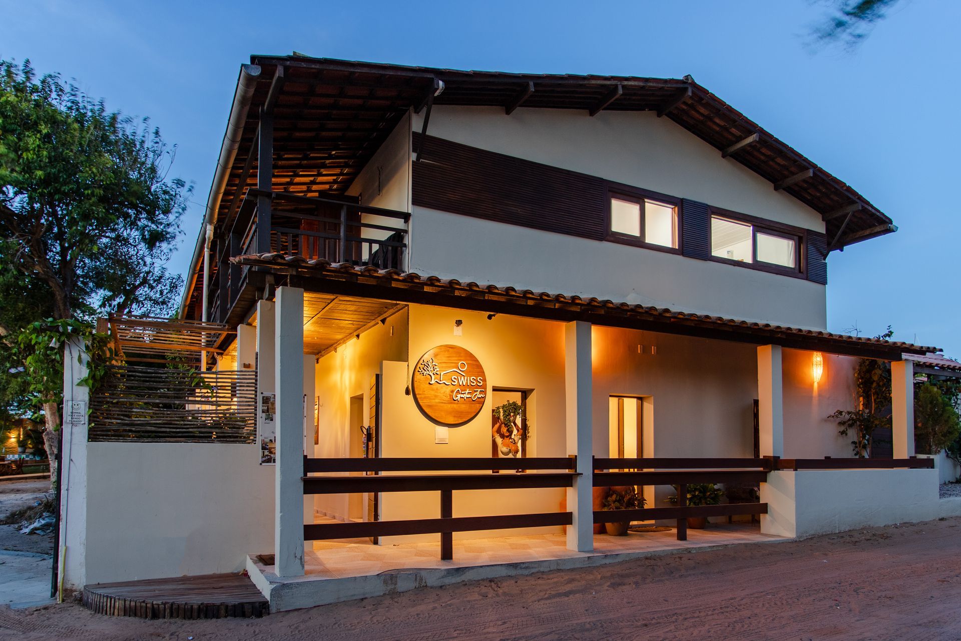 Uma grande casa branca com uma cerca de madeira na frente