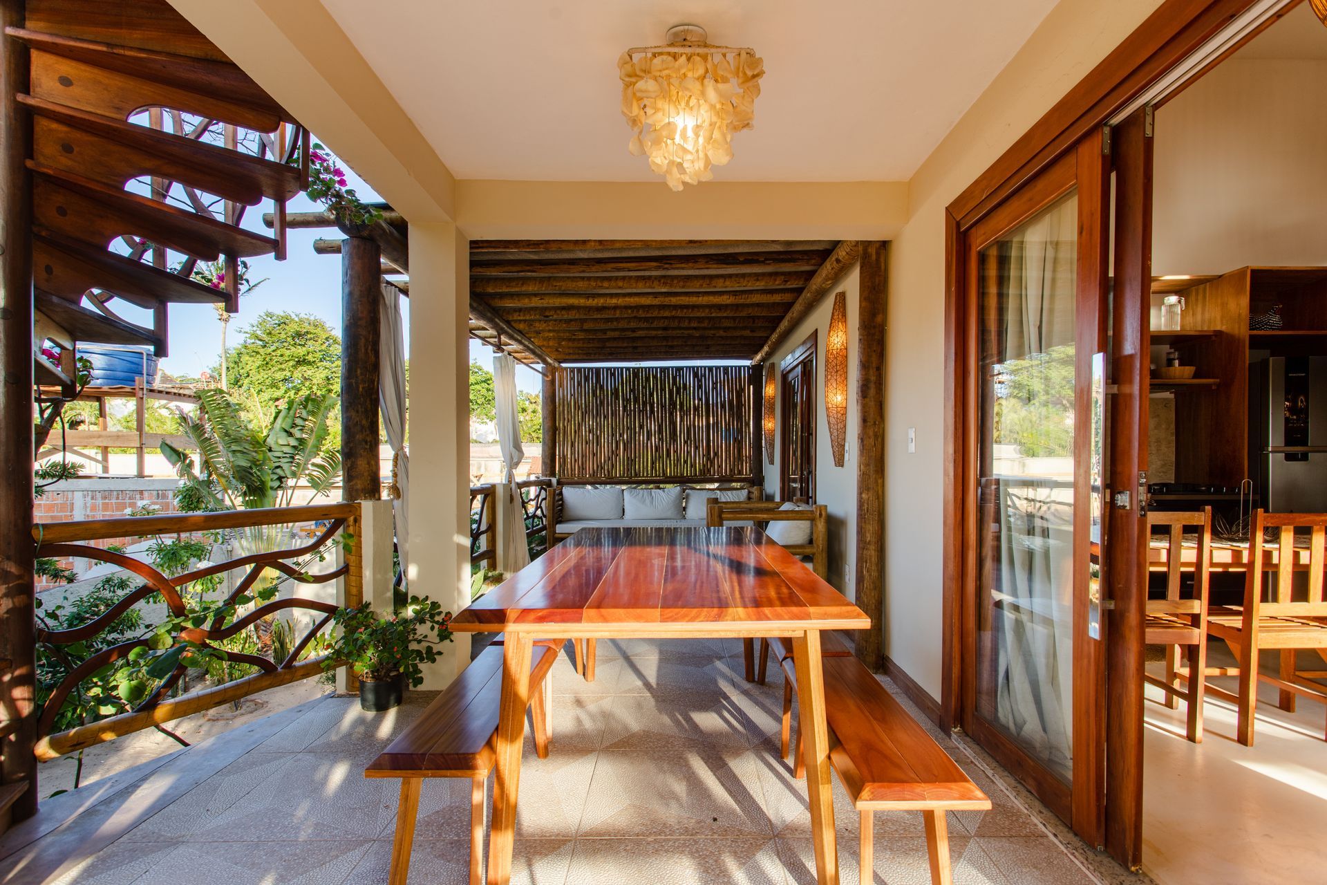 Uma varanda com mesa e bancos de madeira