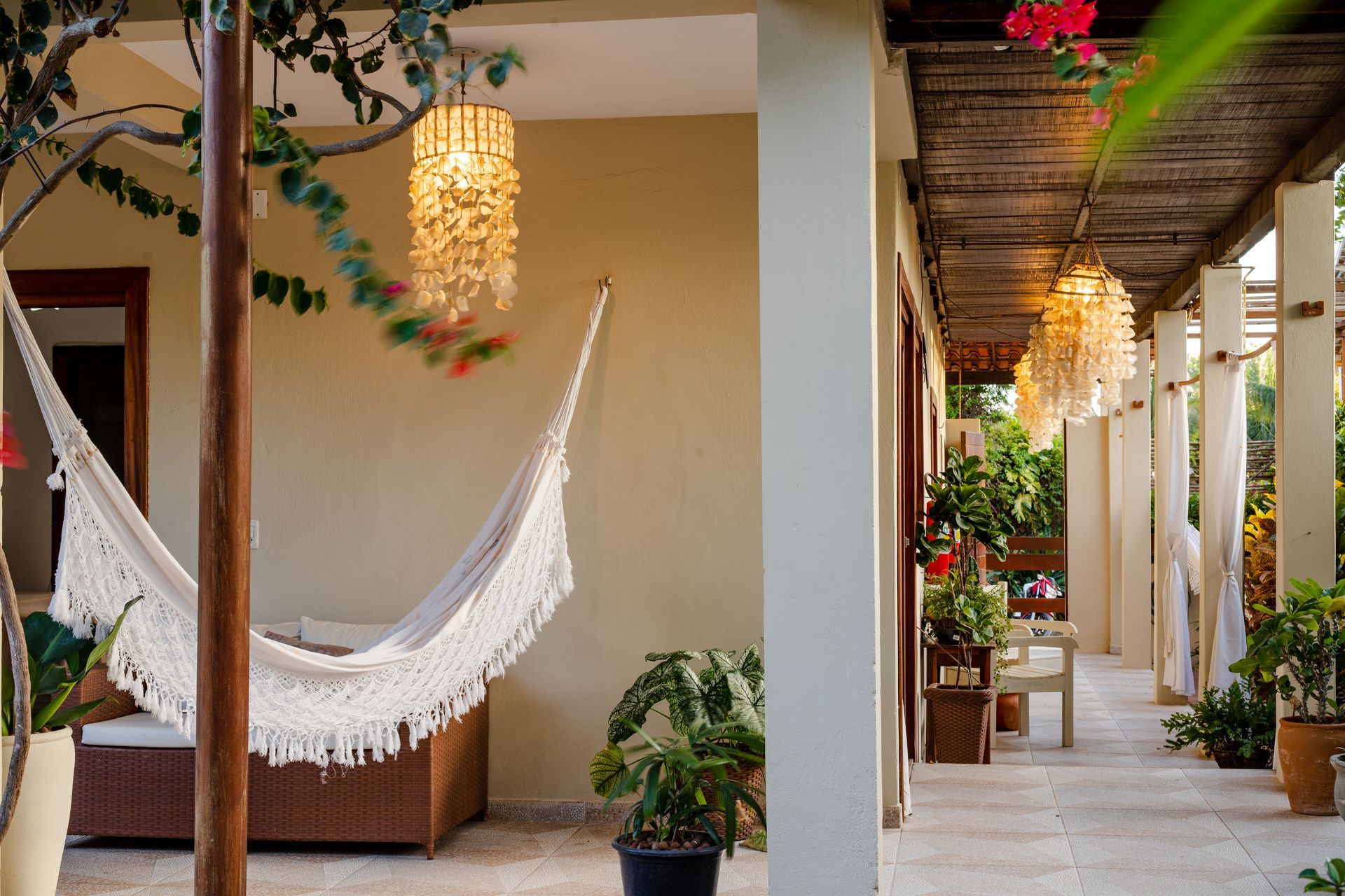 Uma rede branca está pendurada em um poste na varanda