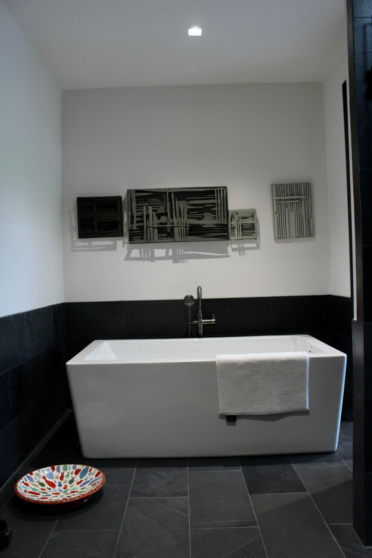 A bathtub in a bathroom with black and white walls