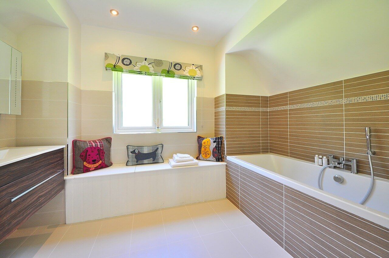 A bathroom with a bathtub and a window.